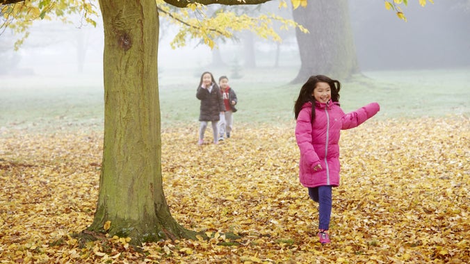 A family playing outside at Osterley Park and House, London in autumn